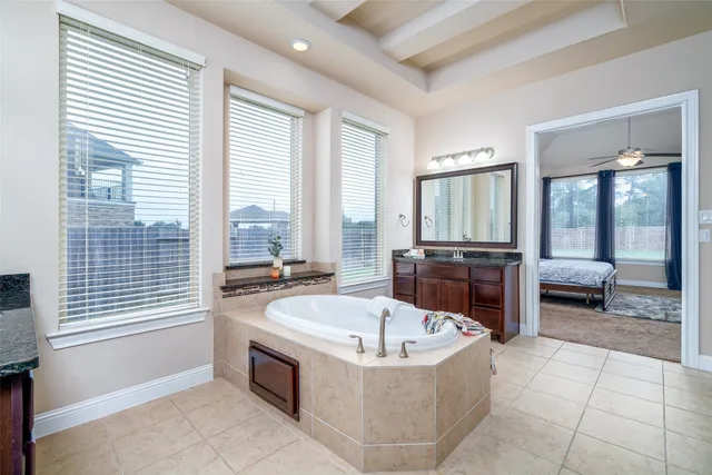 a spacious bathroom with a tub and large windows