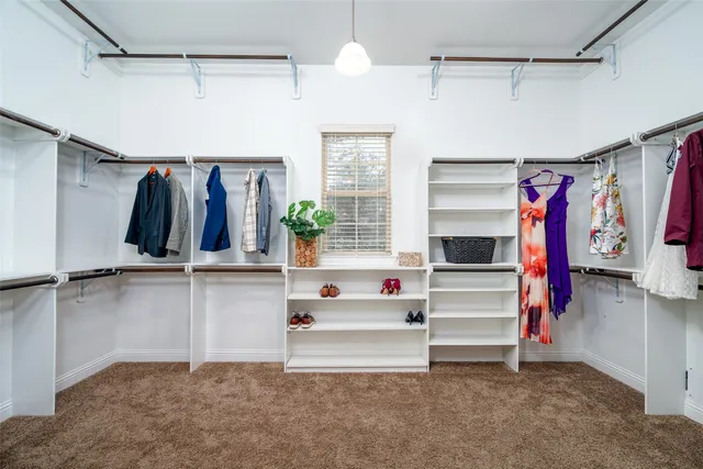 a view of walk in closet with clothes and shoes