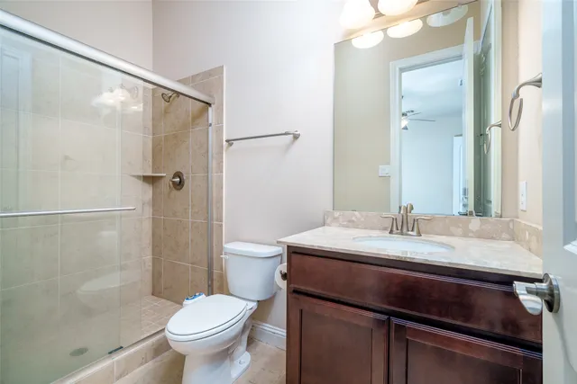 a bathroom with a granite countertop sink toilet and shower