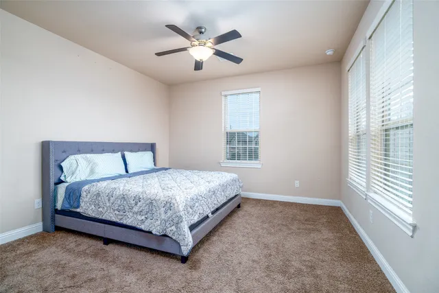 a spacious bedroom with a bed and a large window