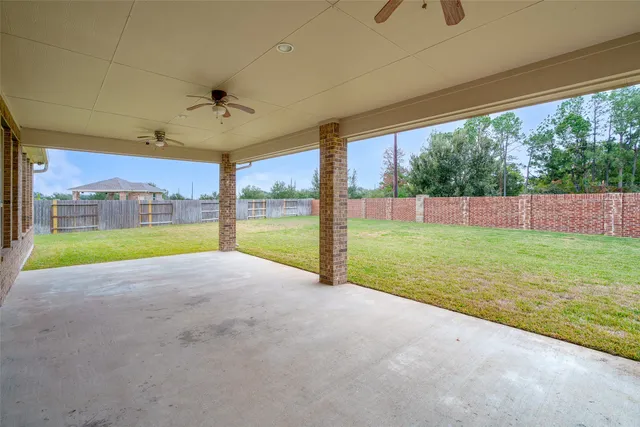 a view of a yard with porch and wooden fence