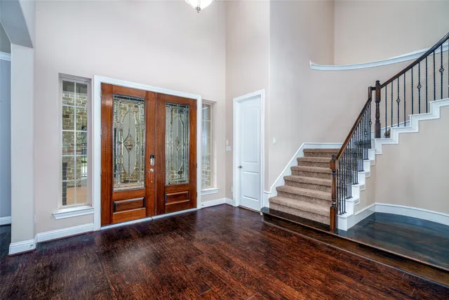 a view of a hallway with wooden floor and stairs