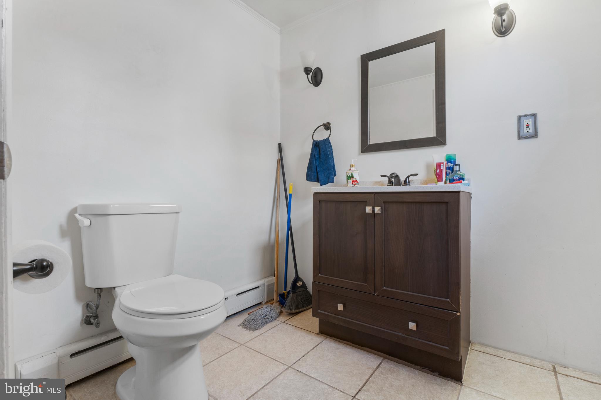 69 Reed Avenue Hamilton, NJ 08610 - Photo 7 of 17 a bathroom with a toilet sink and mirror