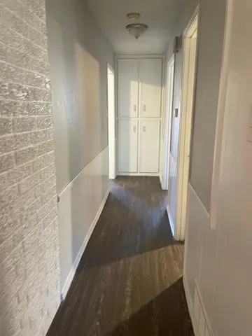 a view of a hallway with wooden floor and staircase
