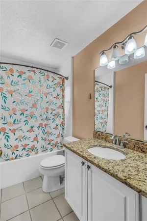 a bathroom with a granite countertop sink a toilet and a mirror