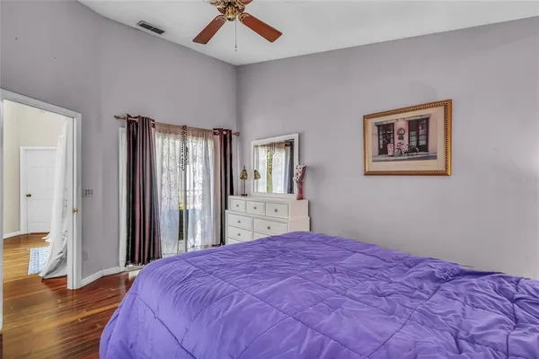 a bedroom with a large bed and wooden floor