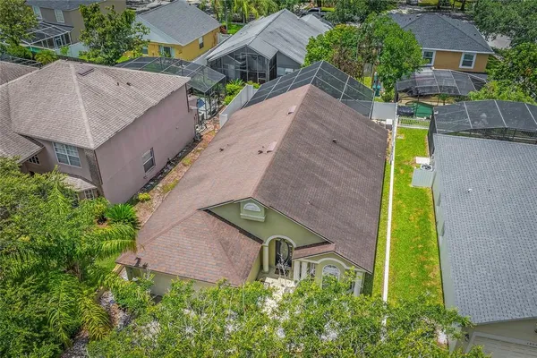 an aerial view of a house with swimming pool and large trees