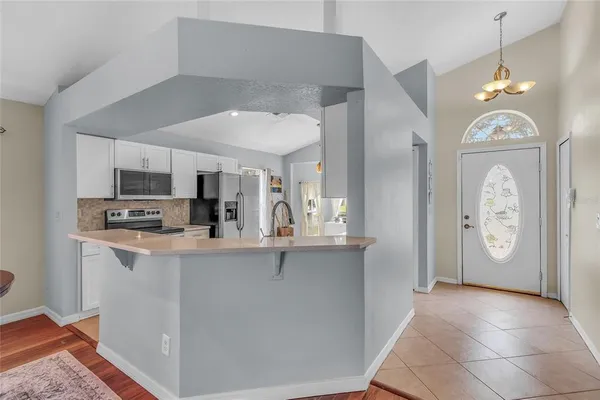 a view of a kitchen with fridge and wooden floor