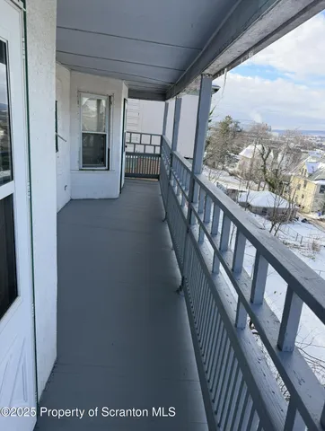 a view of a hallway with wooden floor and stairs