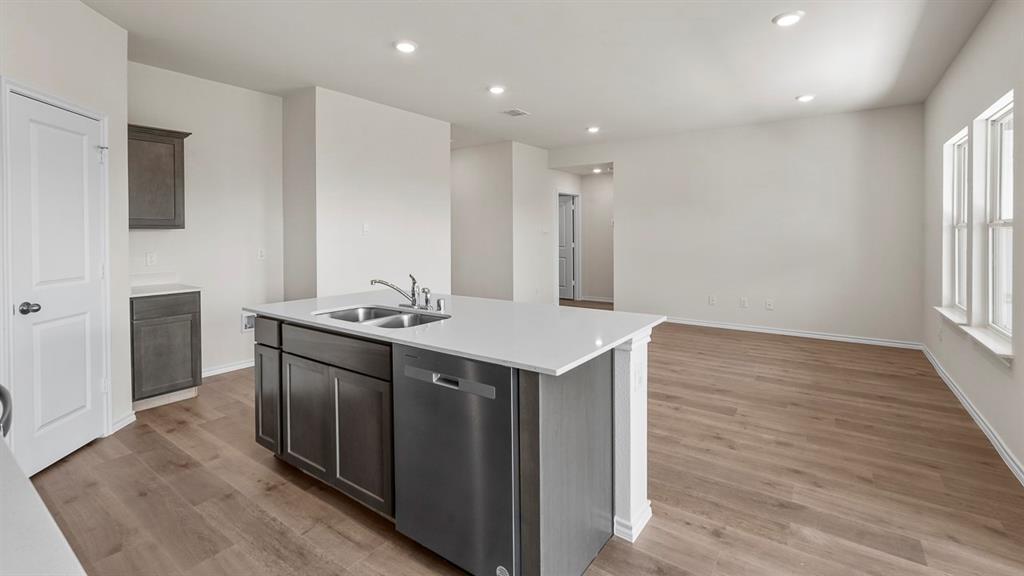 1675 Mantle Road Crandall, TX 75114 - Photo 5 of 27 Open-concept living space featuring a central kitchen island with a double basin sink and stainless steel dishwasher