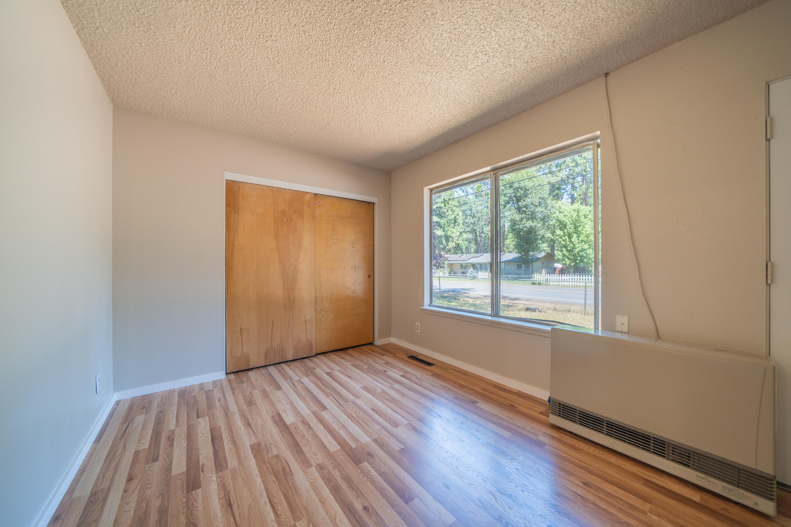 37347 Cypress Avenue Burney, CA 96013 - Photo 12 of 62 a view of an empty room with wooden floor and a window