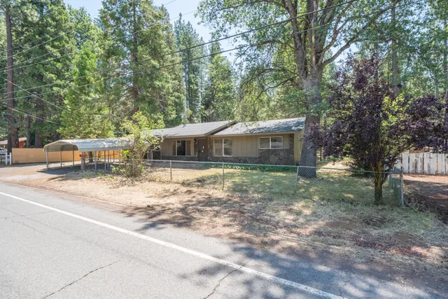 a front view of a house with a yard and trees