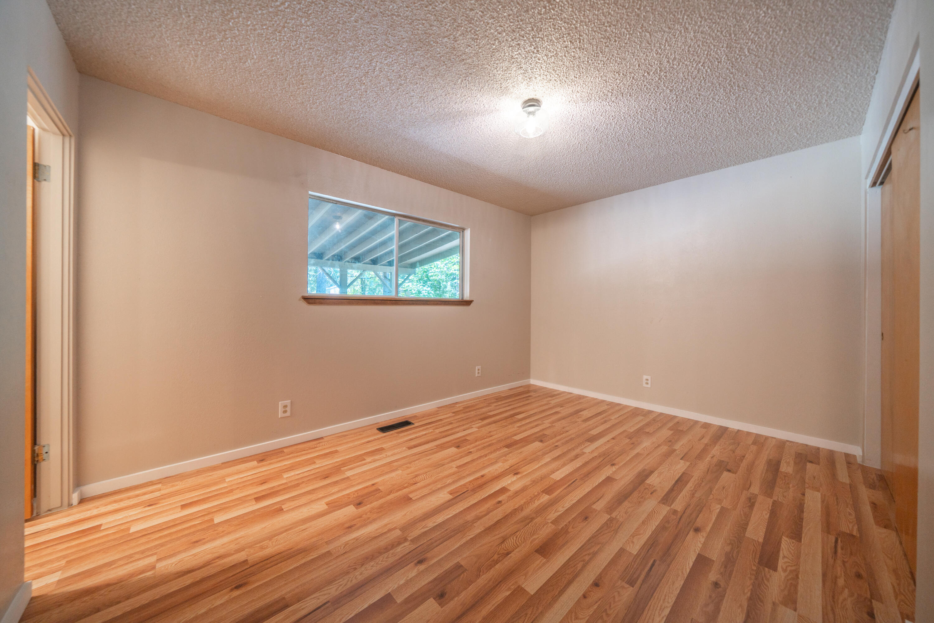37347 Cypress Avenue Burney, CA 96013 - Photo 30 of 62 an empty room with wooden floor and windows