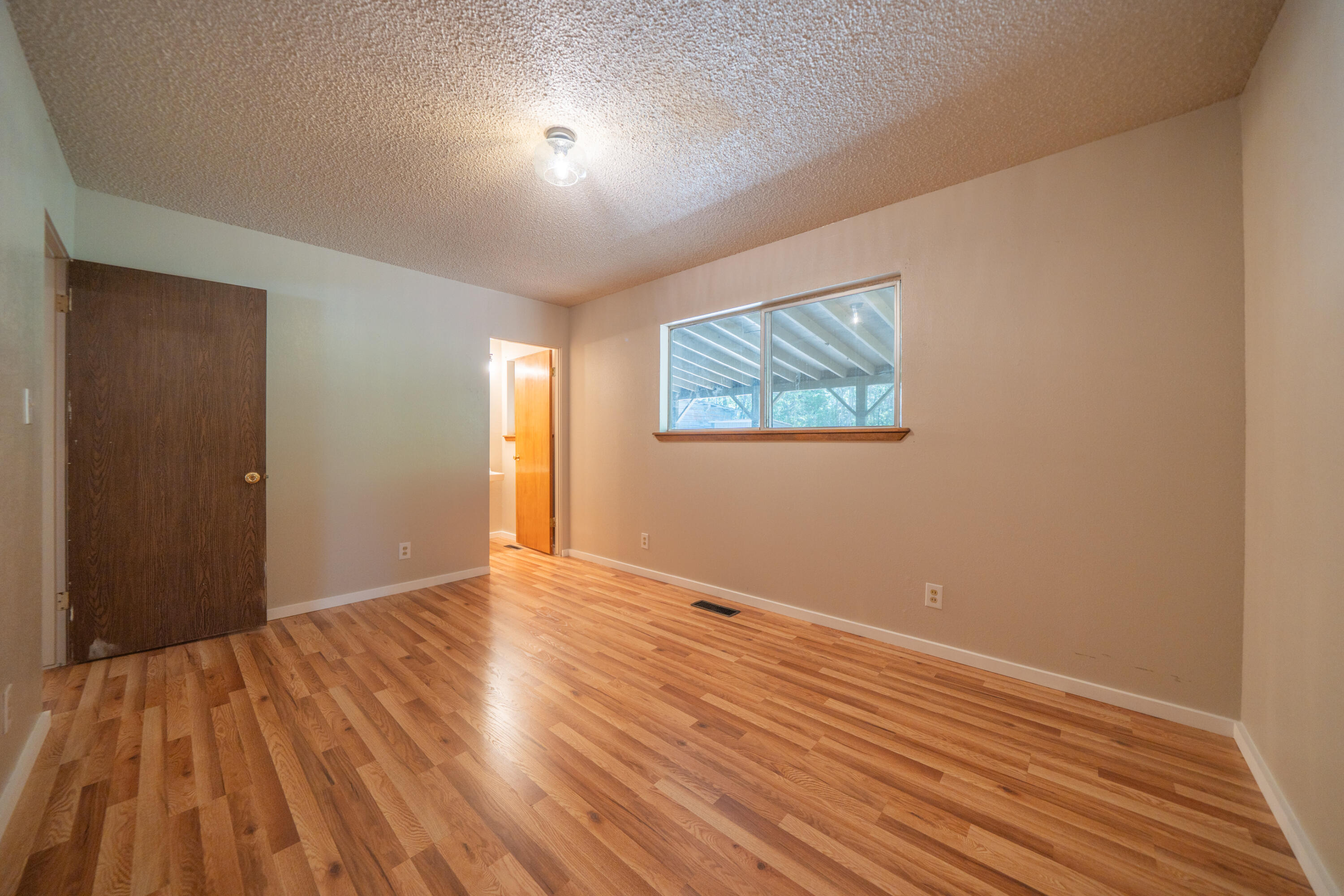 37347 Cypress Avenue Burney, CA 96013 - Photo 31 of 62 a view of an empty room with wooden floor and a window