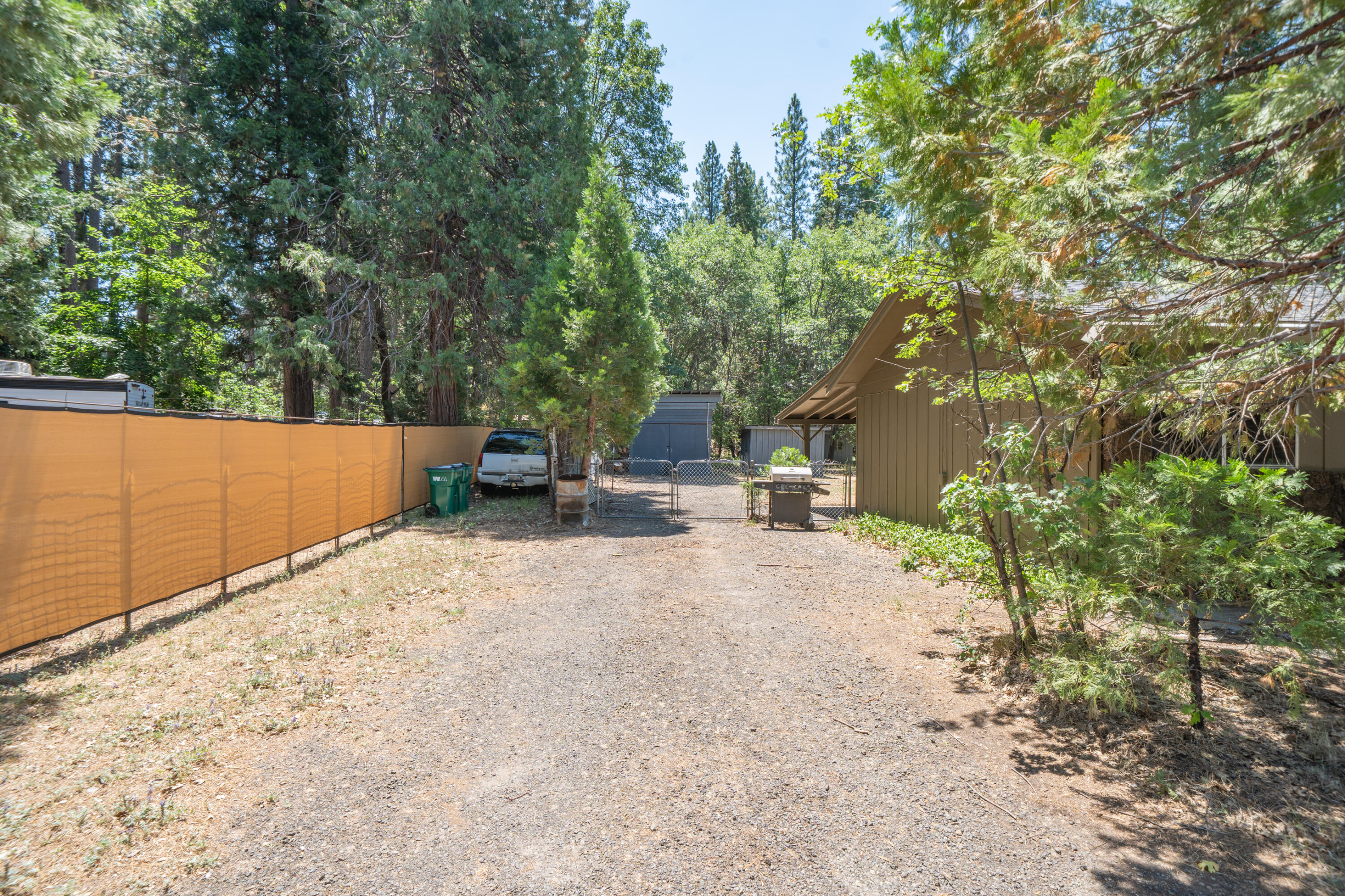 37347 Cypress Avenue Burney, CA 96013 - Photo 5 of 62 a backyard of a house with table and chairs under an umbrella