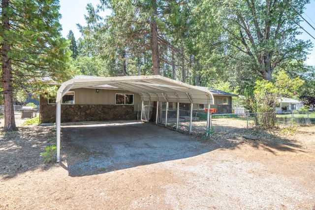a view of a yard with a house and a large tree