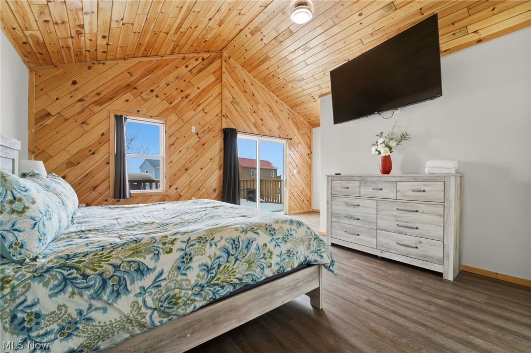 5919 Lake Road West, Unit 32 Ashtabula, OH 44004 - Photo 14 of 23 Bedroom featuring wood walls, a vaulted wood ceiling, wood finished floors, and access to outside