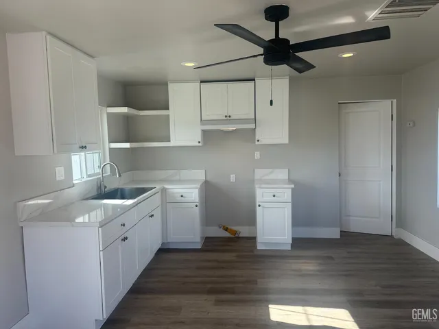 a kitchen with a sink cabinets and wooden floor