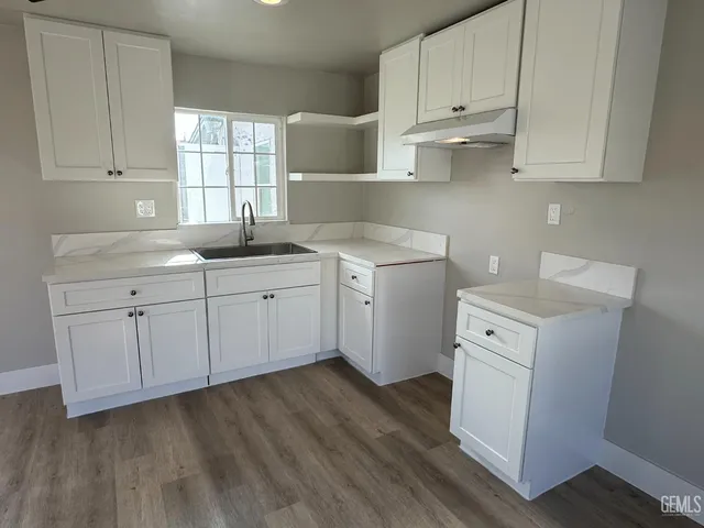 a kitchen with a sink cabinets and a window