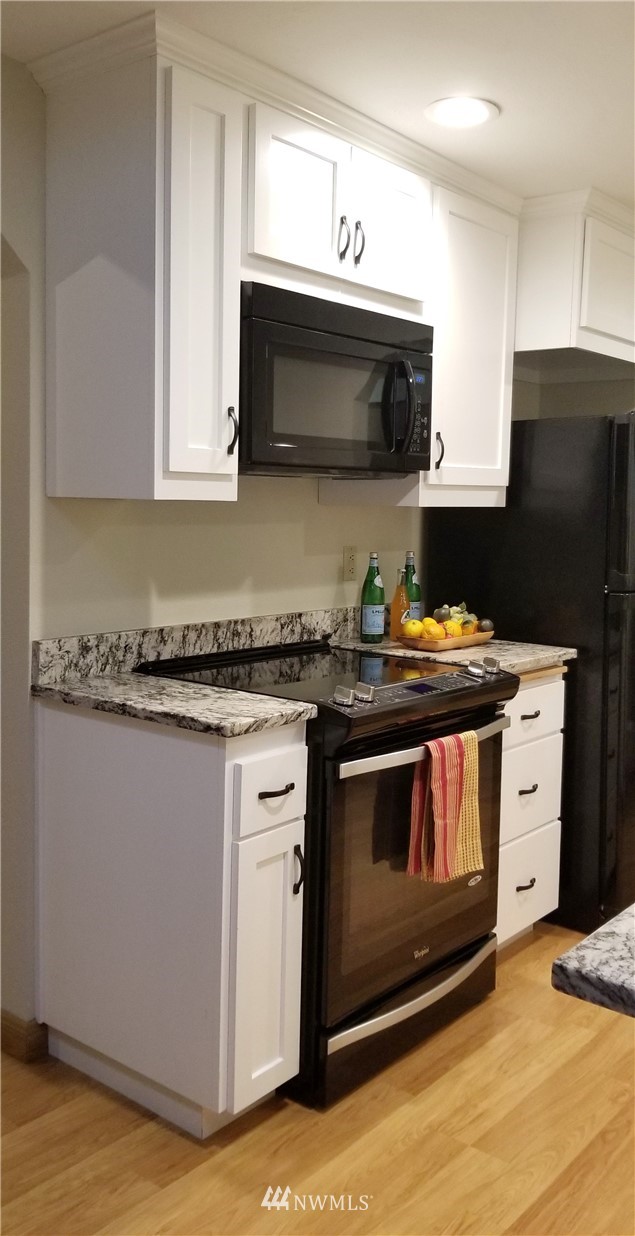36308 25th Place South Federal Way, WA 98003 - Photo 7 of 27 a kitchen with stainless steel appliances a stove a microwave a sink and cabinets
