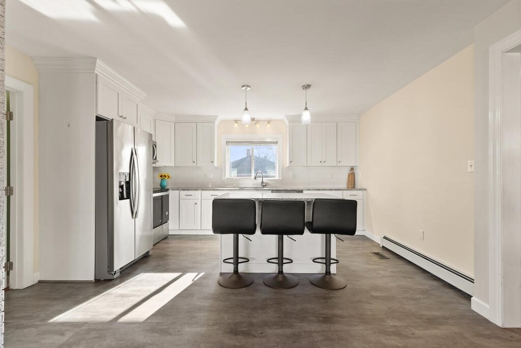 122 Gilman Street Nashua, NH 03060 - Photo 14 of 31 a kitchen with stainless steel appliances kitchen island granite countertop a refrigerator and cabinets