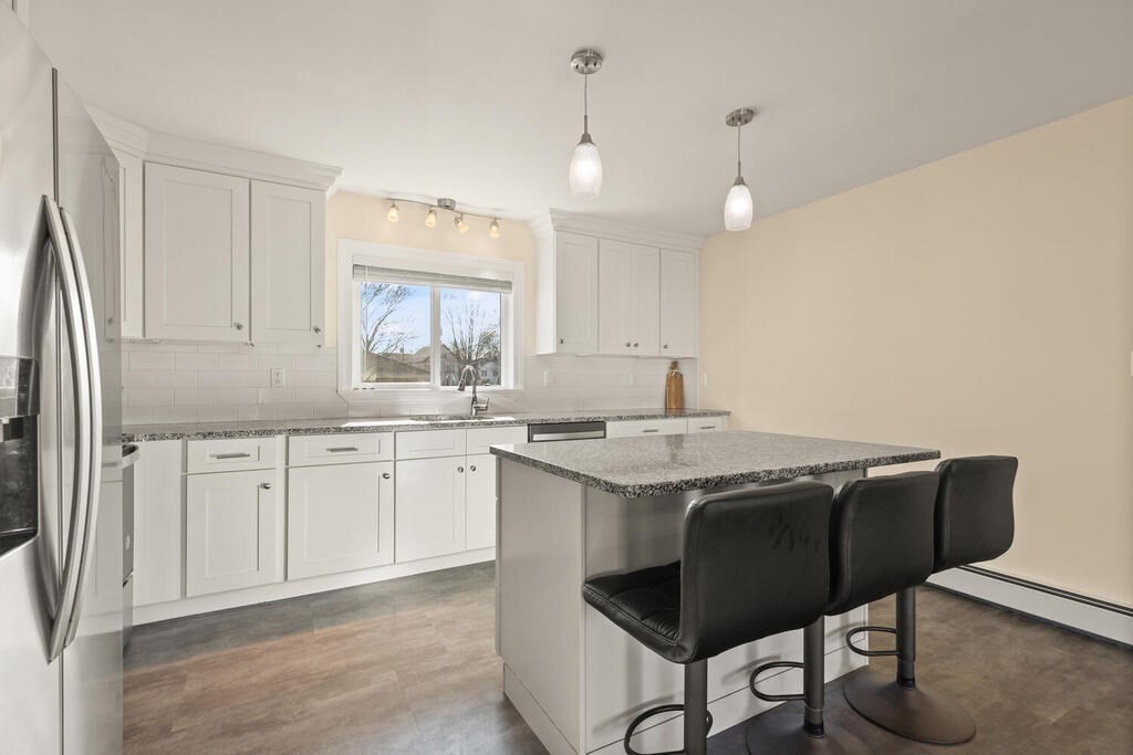 122 Gilman Street Nashua, NH 03060 - Photo 16 of 31 a kitchen with stainless steel appliances granite countertop a sink a stove a refrigerator and island with wooden floor