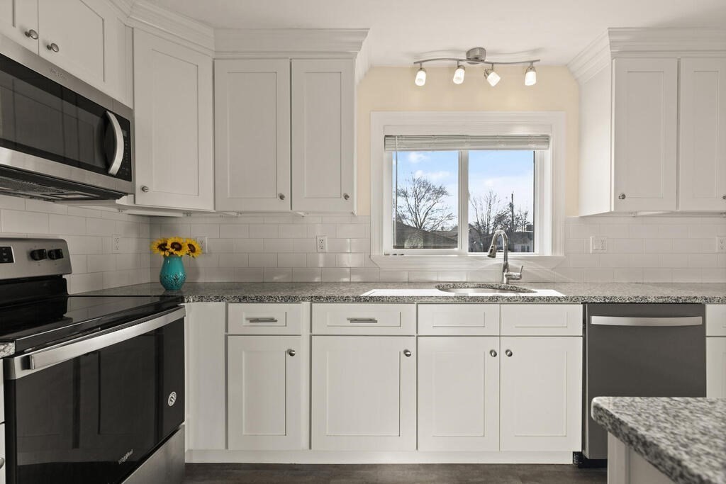 122 Gilman Street Nashua, NH 03060 - Photo 17 of 31 a kitchen with stainless steel appliances granite countertop a sink dishwasher a stove and a microwave oven with cabinets