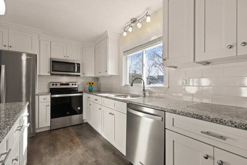 122 Gilman Street Nashua, NH 03060 - Photo 18 of 31 a kitchen with granite countertop white cabinets and stainless steel appliances