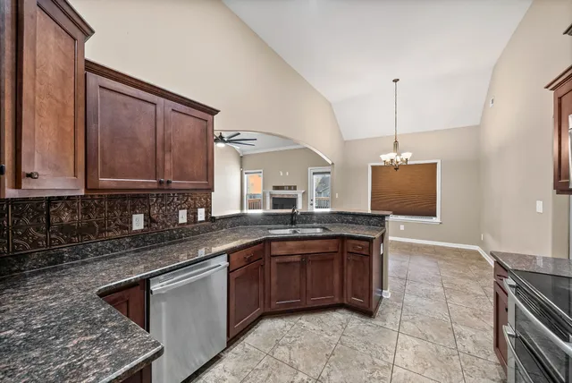 a kitchen with stainless steel appliances granite countertop a sink and a stove