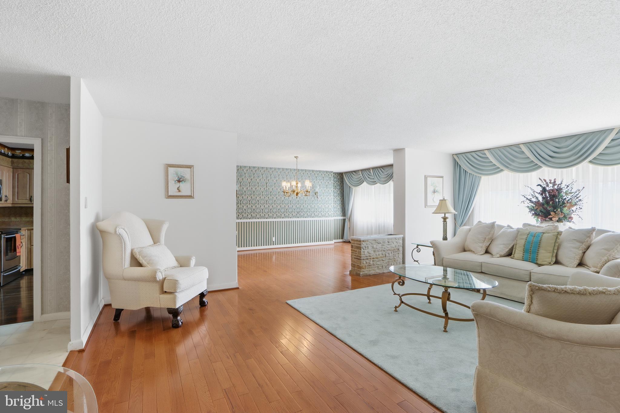 7111 Park Heights Avenue, Unit 104 Baltimore, MD 21215 - Photo 16 of 39 a living room with furniture rug and a lamp