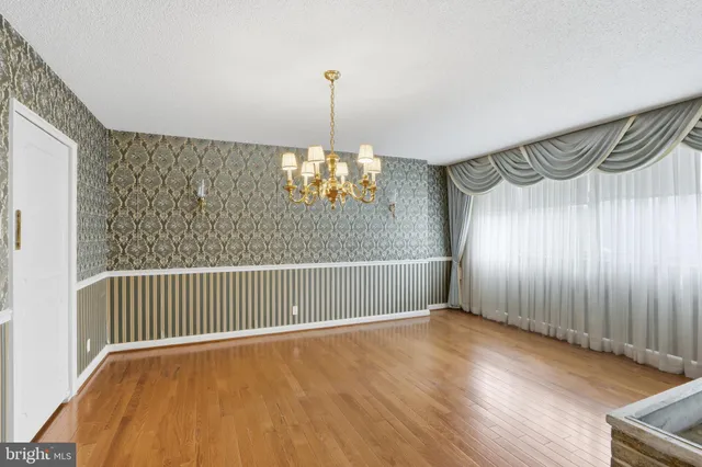 a view of a room with wooden floor staircase and a ceiling fan