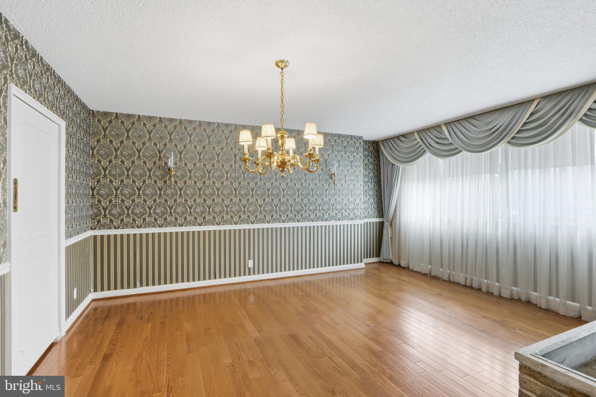 7111 Park Heights Avenue, Unit 104 Baltimore, MD 21215 - Photo 20 of 39 a view of a room with wooden floor staircase and a ceiling fan