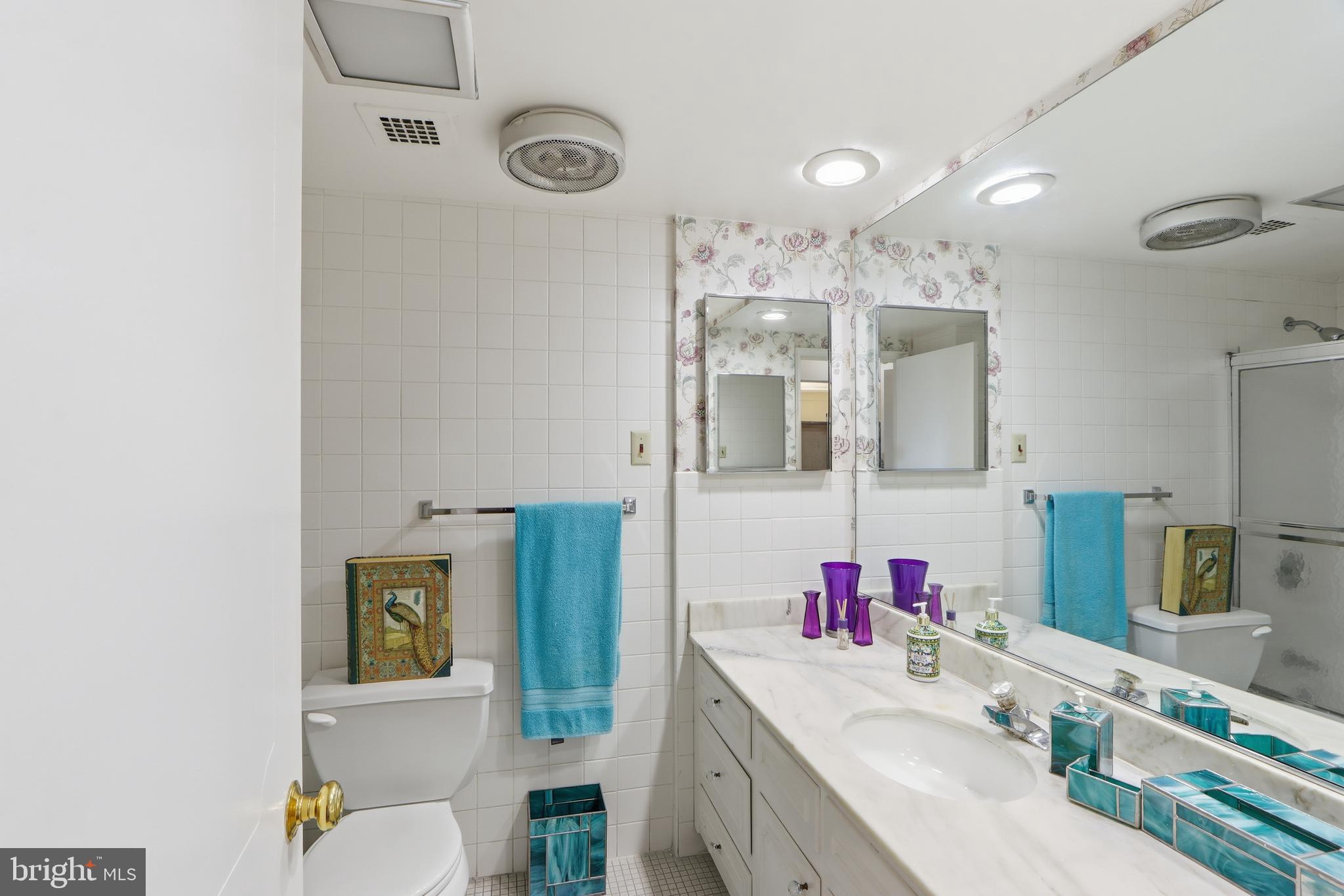 7111 Park Heights Avenue, Unit 104 Baltimore, MD 21215 - Photo 29 of 39 a bathroom with a granite countertop sink mirror and vanity