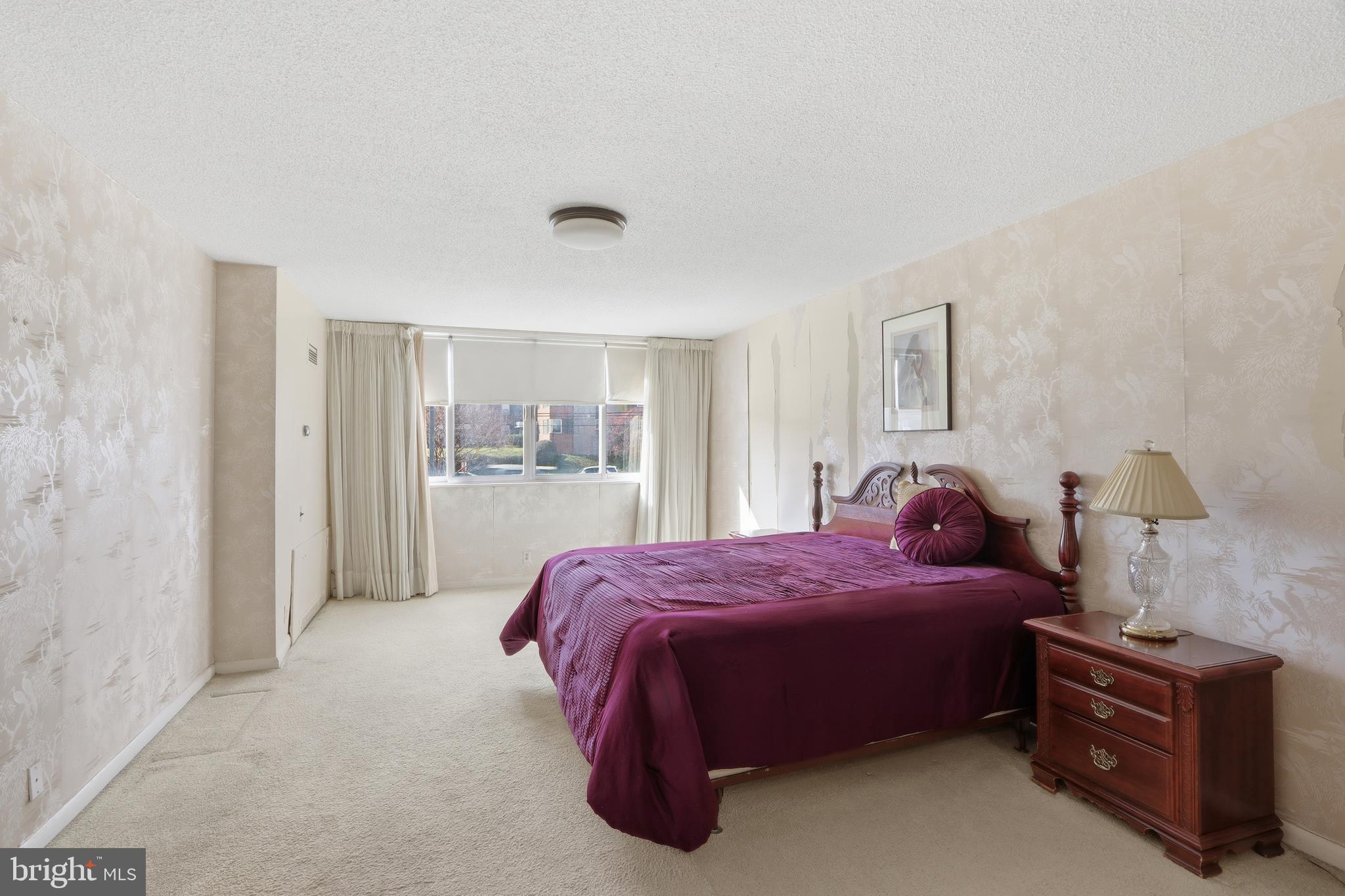 7111 Park Heights Avenue, Unit 104 Baltimore, MD 21215 - Photo 33 of 39 a bedroom with a bed and wooden floor