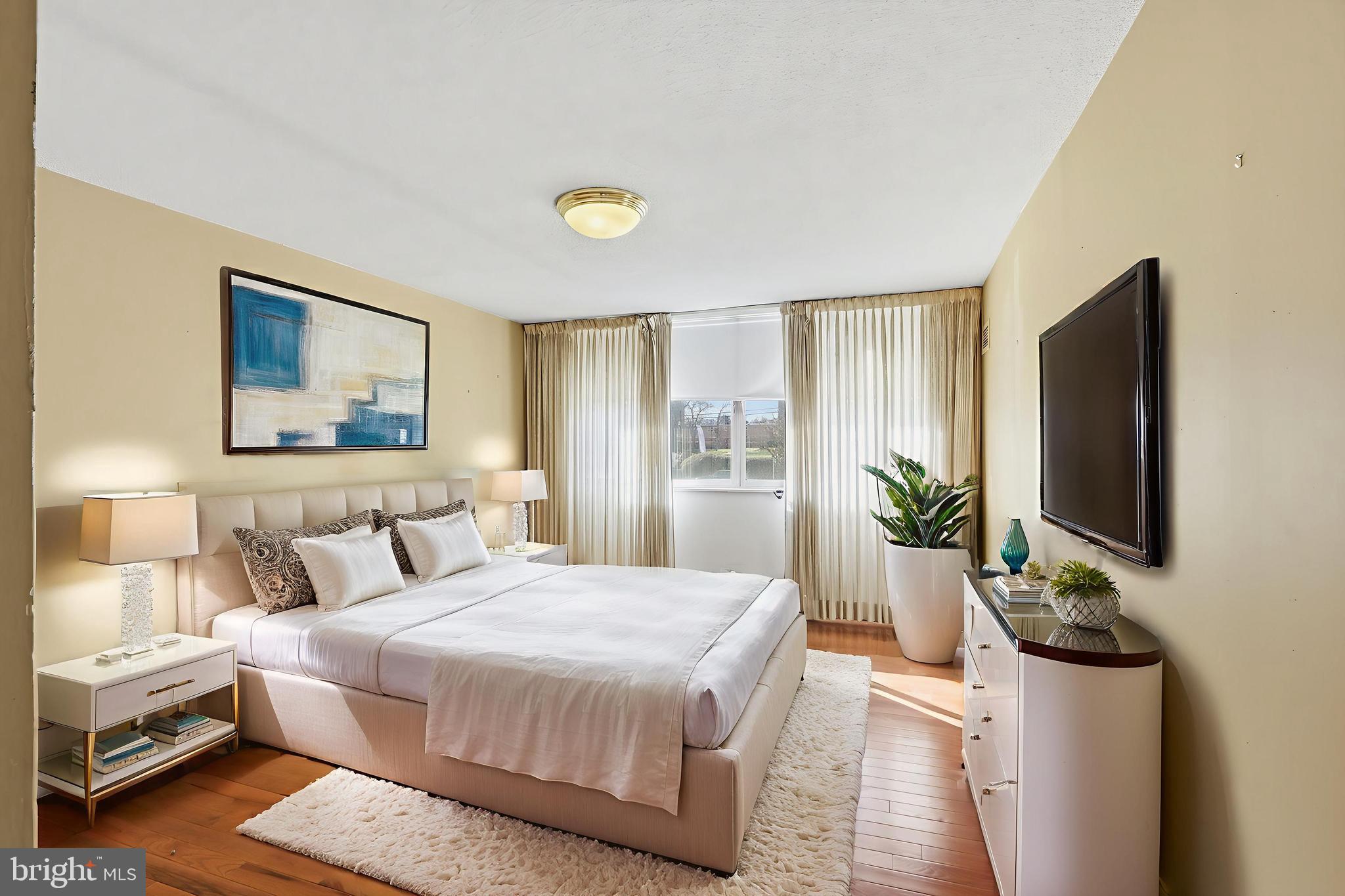 7111 Park Heights Avenue, Unit 104 Baltimore, MD 21215 - Photo 36 of 39 a bedroom with a bed and a flat screen tv