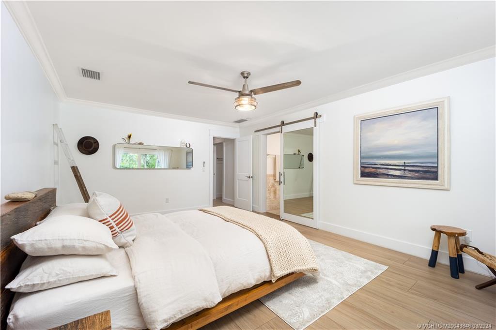 3713 Southeast Matanzas Street Stuart, FL 34996 - Photo 23 of 53 a bedroom with a bed and a table with wooden floor