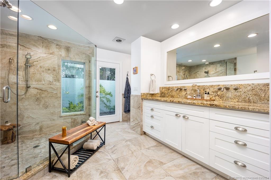 3713 Southeast Matanzas Street Stuart, FL 34996 - Photo 26 of 53 a spacious bathroom with a granite countertop sink and a mirror