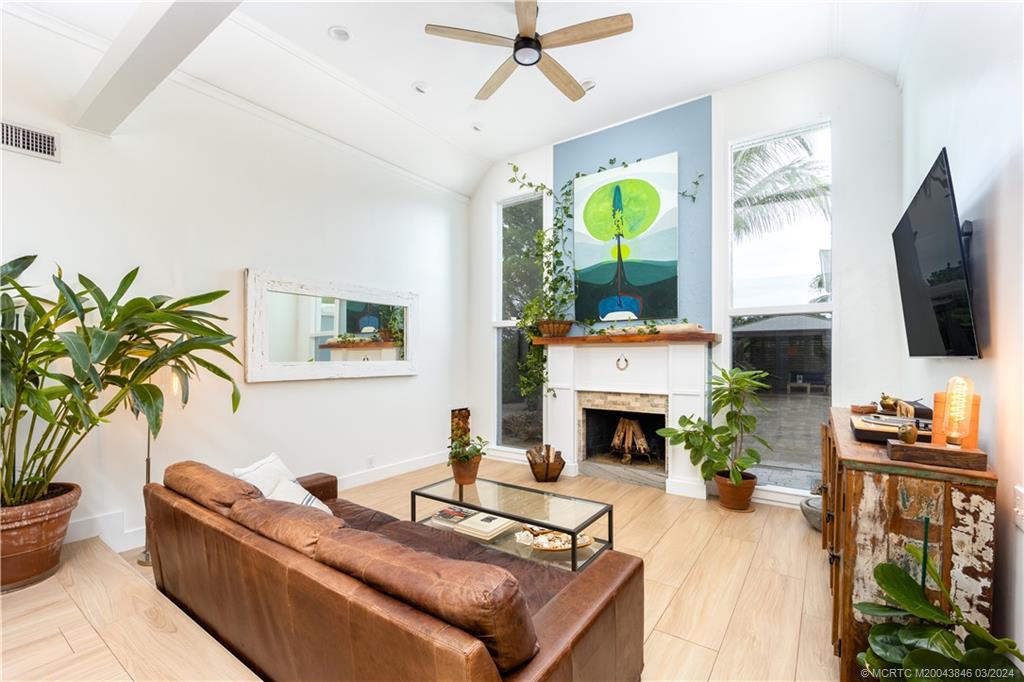 3713 Southeast Matanzas Street Stuart, FL 34996 - Photo 35 of 53 a living room with furniture a fireplace and a flat screen tv