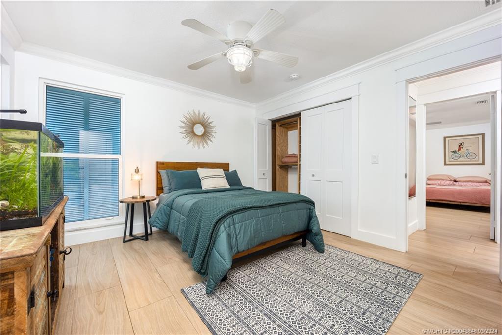 3713 Southeast Matanzas Street Stuart, FL 34996 - Photo 43 of 53 a bedroom with a large bed a chandelier and windows