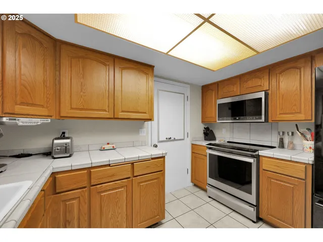 a kitchen with stainless steel appliances granite countertop a sink stove and microwave