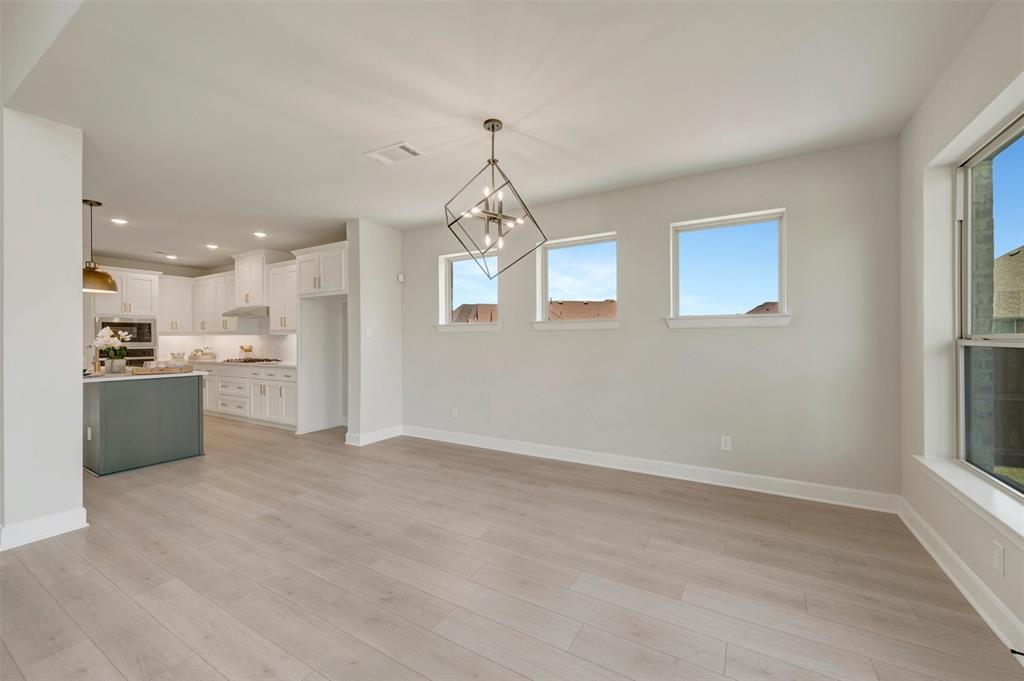 4308 Palomino Road Aubrey, TX 76227 - Photo 24 of 40 a view of a kitchen with kitchen island wooden floor center island and stainless steel appliances