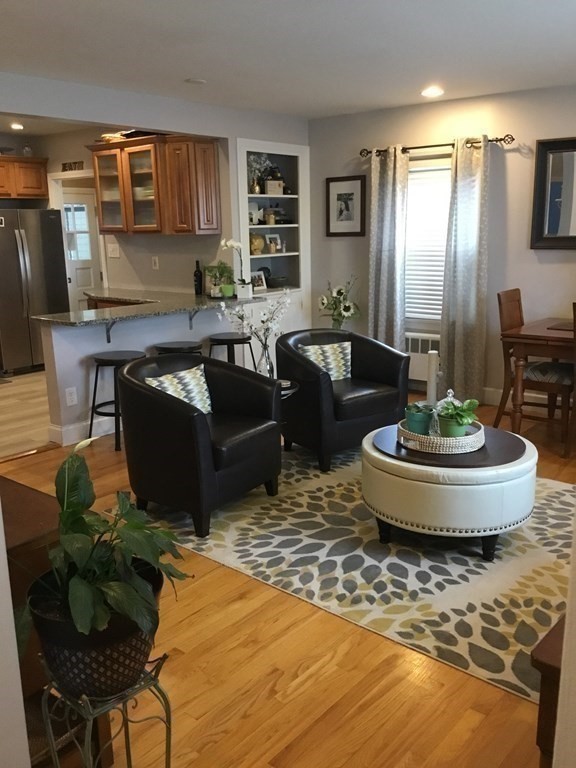 94 Winthrop Street Fall River, MA 02721 - Photo 13 of 29 a living room with couches and a dining table with wooden floor