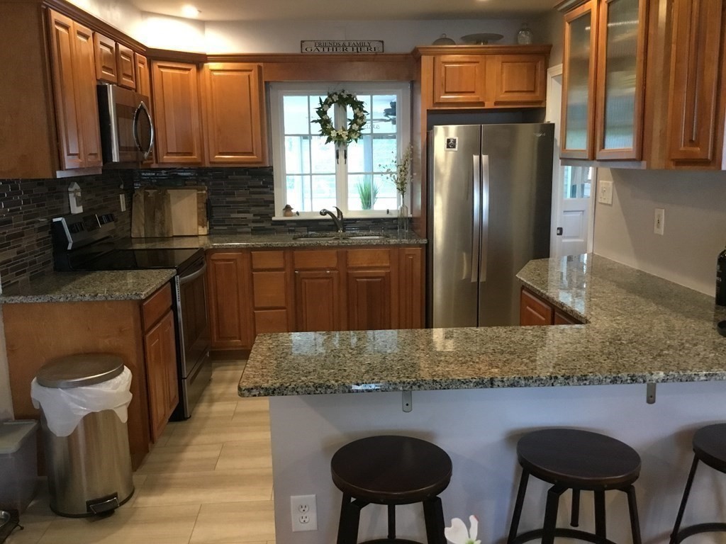 94 Winthrop Street Fall River, MA 02721 - Photo 6 of 29 a kitchen with stainless steel appliances granite countertop a sink refrigerator stove and microwave