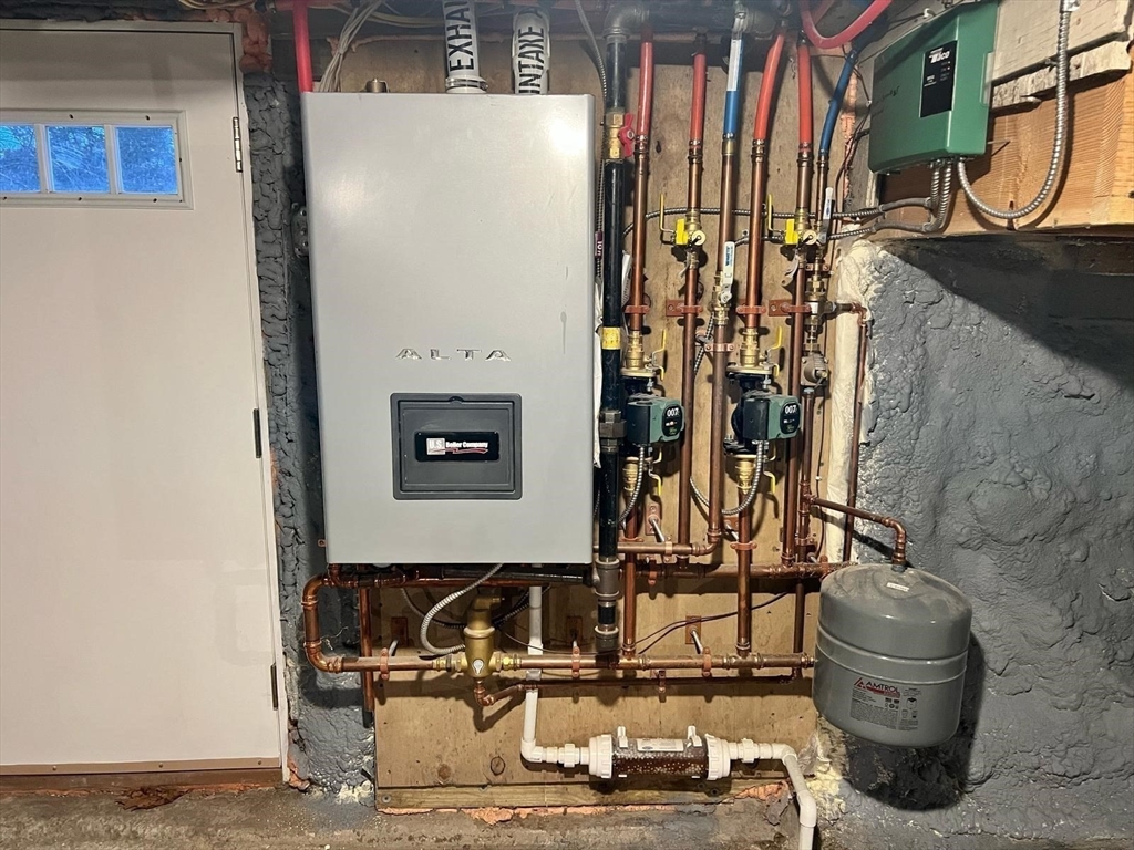 81 Stuart Street Gardner, MA 01440 - Photo 22 of 24 a room with water heater and wooden walls