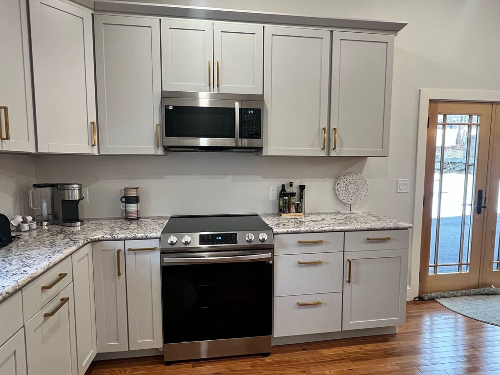 81 Stuart Street Gardner, MA 01440 - Photo 3 of 24 a kitchen with stainless steel appliances granite countertop a stove a microwave and cabinets