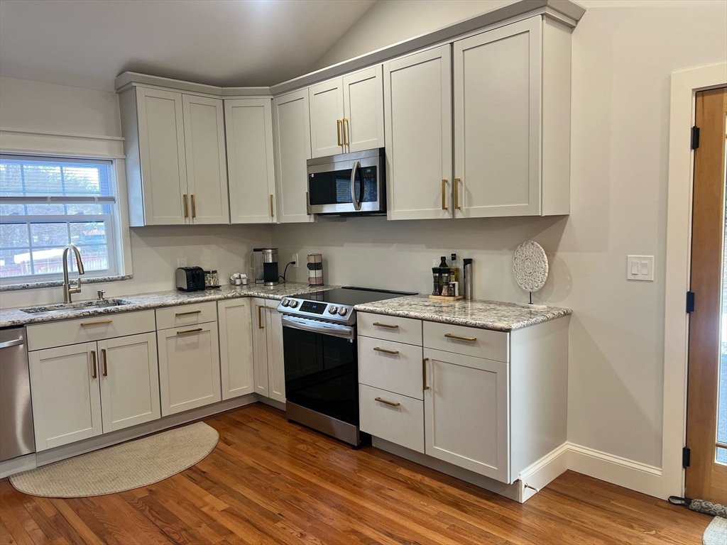 81 Stuart Street Gardner, MA 01440 - Photo 4 of 24 a kitchen with stainless steel appliances granite countertop a sink and cabinets with wooden floor
