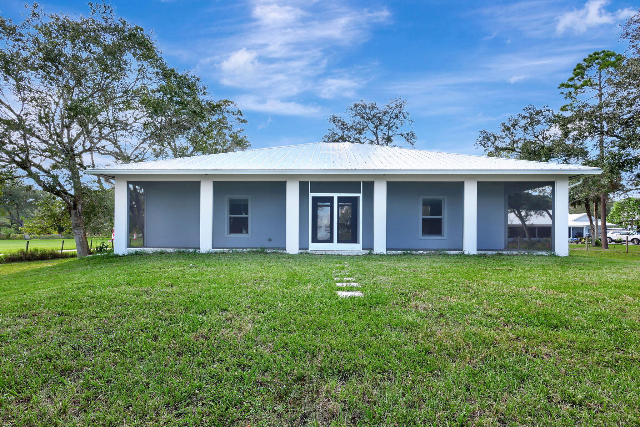 6289 South Header Canal Road Port St. Lucie, FL 34987 - Photo 2 of 52 front view of the brick house and a yard