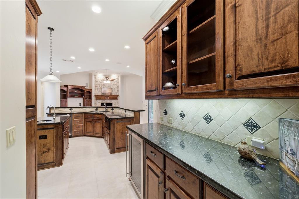 970 Crystal Cove Oak Point, TX 75068 - Photo 8 of 40 a kitchen with granite countertop a sink a stove and a wooden cabinets