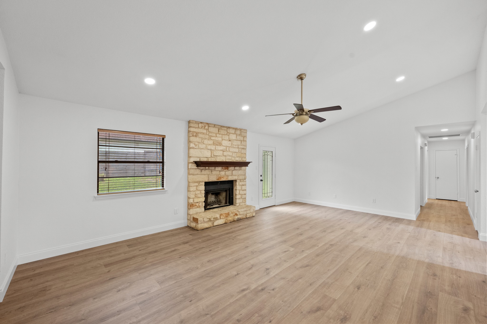 7210 Smokey Hill Road Austin, TX 78736 - Photo 9 of 29 A spacious living area offers vaulted ceilings, warm wood flooring, and a beautiful stone fireplace.