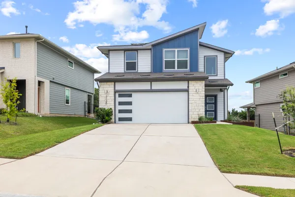 a front view of a house with a yard and garage